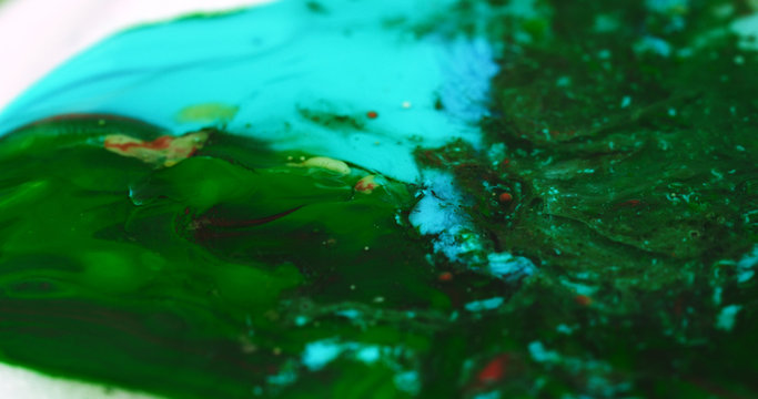 Macro Paint with Vibrant Color Palette. Oil Mixed with Bright Green and Teal Dye and Paint.