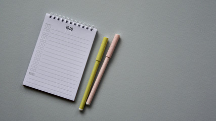 Notepad with two pens on a blue paper background. Top view. Close-up. Flat lay.