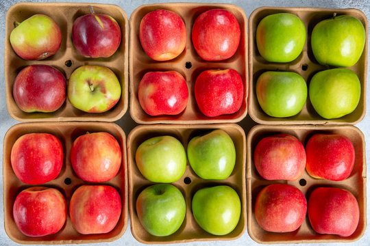 Red and green apples on pulp paper food trays. Top view.