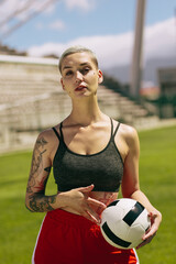Female footballer holding a ball on the field