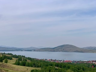 Beautiful scenic view to green forest valley and great mountains far in sunny day. Awesome landscape of vast expanses in sunlight. Wonderful vivid scenery with green forest mountains.