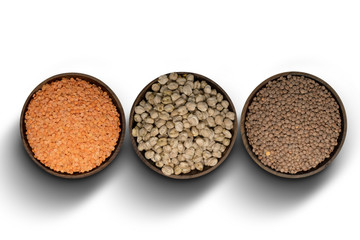 Different Lentils in a wooden bowl on white background