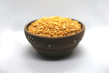 Yellow  Lentils in a wooden bowl on white background