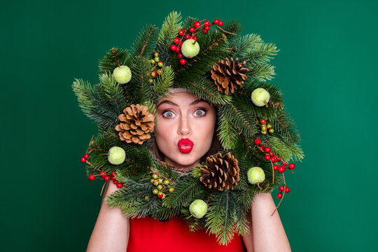 Close-up portrait of her she nice attractive pretty flirty coquettish funky girl holding in hands festive wreath having fun sending air kiss good mood isolated over green color background