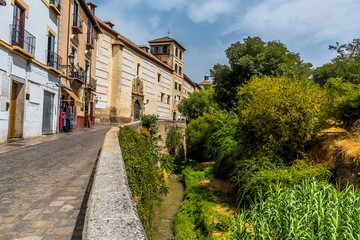 Fototapeta na wymiar A view over the Darro river in the Albaicin district of Granada in summertime