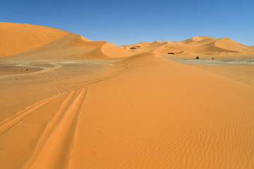 Fototapeta na wymiar SAFARI IN THE SAHARA DESERT IN ALGERIA. NATIONAL PARK OF TADRART. SAND DUNES AND ROCK FORMATIONS. 
