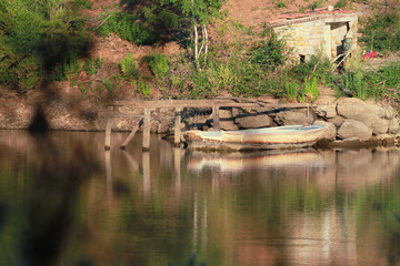 Small lake in Tuscan Maremma at sunset with wooden boat.