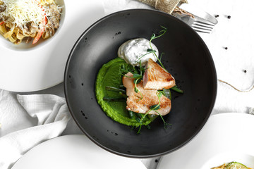 Black plate of tuna steak. white background