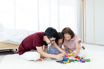 A young girl with dysfunction, brain learning disabilities,Down Syndrome constellation playing, and learning a multicolored wooden toy .