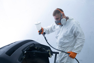 Painting the bumper of the car in the spray booth. Car mechanic at work.