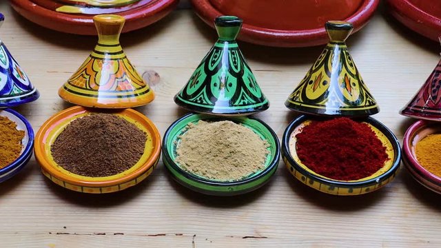  Diversity of Moroccan powder herbs in colorful ceramic tagines