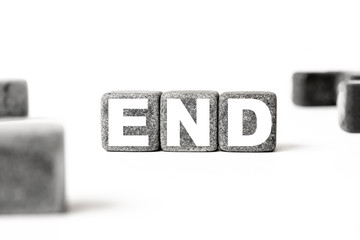 three stone cubes inscribed with the word end among the cubes on a white background. Strong business concept