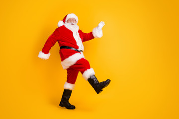 Fototapeta na wymiar Full length body size profile side view of his he nice funny cheerful thick white-haired Santa St Nicholas going dancing having fun isolated bright vivid shine vibrant yellow color background