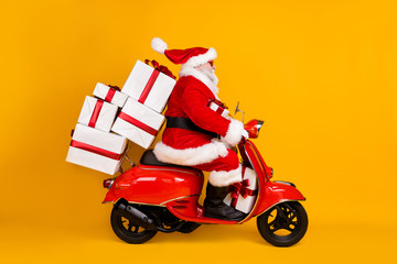 Profile side view of his he nice funny fat St Nicholas driving motor bike hurry up delivering pile stack gifts Eve Noel winter tradition isolated bright vivid shine vibrant yellow color background