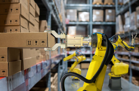 yellow robotic arm carry cardboard box in warehouse

