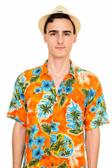 Studio shot of young handsome Caucasian man wearing Hawaiian shirt isolated against white background