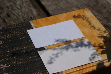 Blank white business card on diary and wooden texture 