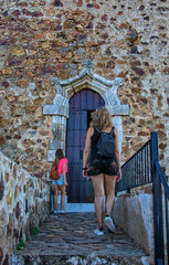 Castillo Fair located in Extremadura, Spain. Stock Photo, Rear view of two hiker girls looking at the front door of a castle.