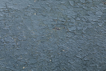 Background of grey cement wall with cracked coating of plaster and paint