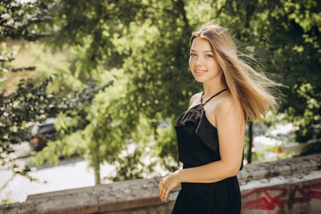 A teenage girl is having a walk in a green city park