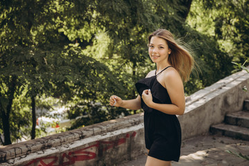 A teenage girl is having a walk in a green city park
