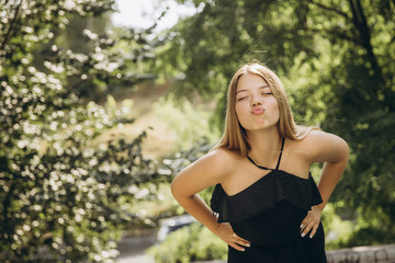 A teenage girl is having a walk in a green city park