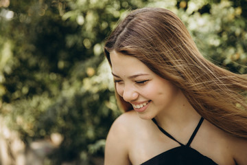 A teenage girl is having a walk in a green city park