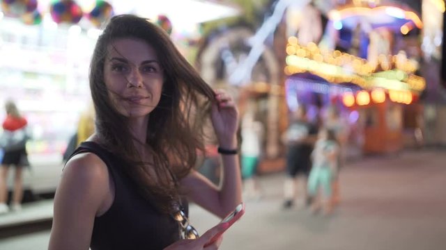 Happy smiling woman using smartphone to film different rides and attractions