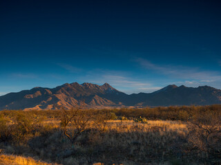 A rugged desert mountain range at sunset