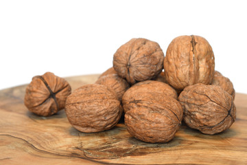 Walnuts on wooden cutting board isolated on white background