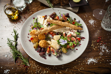 Cheese platter for two: Goat cheese cream, gorgonzola, camembert, grissini and fig jam. Delicious healthy Italian traditional food closeup served for lunch in modern gourmet cuisine restaurant