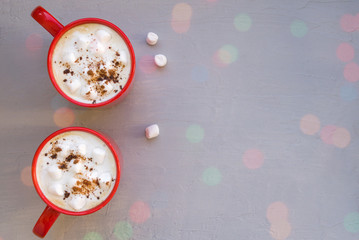 Two red mugs with cappuccino and marshmallow. Template for a card, space for text.