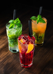 three refreshing cocktails on a wooden background
