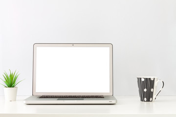 Fototapeta premium Business desk. Open laptop. Screen mockup. Minimal composition. One plant and a cup of coffee. Copy space.