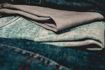 Varios jeans apilados uno sobre otro. Moda y belleza. Pantalones con vista de cerca, detalles....