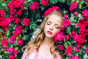 Naklejka na ściany i meble portrait of a young girl with closed eyes against a background of pink roses