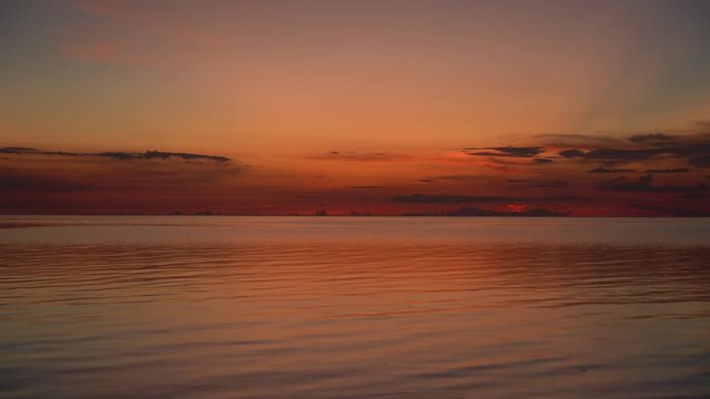 Colorful sunset over calm sea water near tropical beach. Summer vacation concept. Island Koh Phangan, Thailand