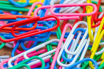 Macro photo of multicolored paper clips. Bright background made of colored paper clips, close-up
