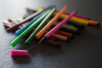 Conjunto de rotuladores de colores sobre superficie negra