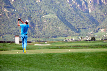 Blurred movement of a male golfer teeing-off.