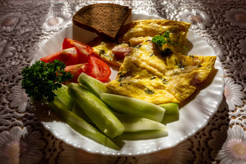 Omelet with vegetable salad. Natural sunlight in the early morning