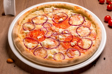 Pizza with feta and salami thin cake, cream, Italian salami, tomatoes