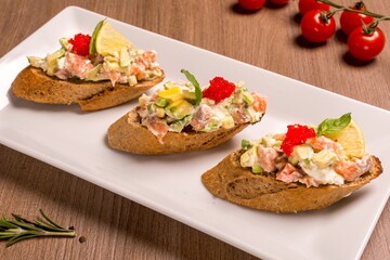 Bruschetta with salmon and avocado dried rye baguette, cream cheese
