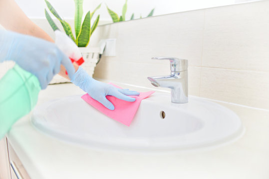 Woman In Gloves Cleaning Bathroom.