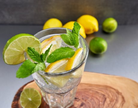 Top view colorful image of glass of lemonade or gin tonic with lemons and lime.