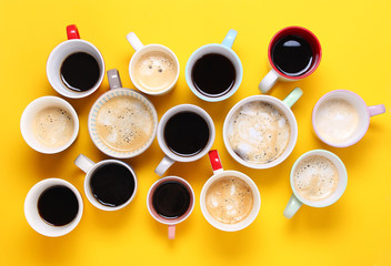 Obraz na płótnie Canvas Group of different cups of coffee on yellow background. Top view,flat lay,copy space.