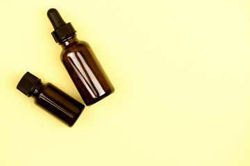 Natural organic cosmetics. Bottles with oils on a yellow background.