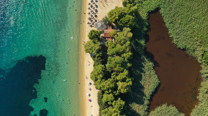 Aerial drone photo of popular paradise turquoise beach of Vromolimnos with small swamp next to it,...