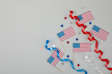 Obraz premium American flags, curly ribbons and stars on gray background