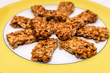 Homemade oat and peanut protein bars on a yellow serving plate.